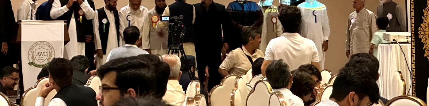 Attending families seated at round tables during the Arain Welfare Community annual gathering